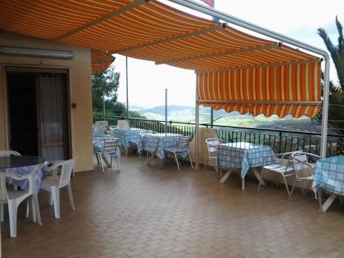 a restaurant with tables and chairs and umbrellas at B&B da Pietro in Calascibetta