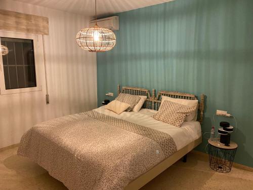 um quarto com uma cama e um lustre em La Morada em Altea
