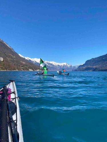 two people on a boat in the water with a sail at Chalet Mignon - your vacation oasis at Lake Brienz in Bönigen