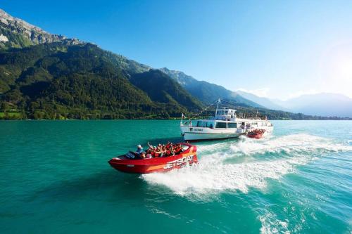 a group of people in a red boat in the water at Chalet Mignon - your vacation oasis at Lake Brienz in Bönigen