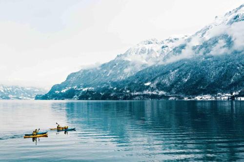 two boats on a lake with mountains in the background at Chalet Mignon - your vacation oasis at Lake Brienz in Bönigen