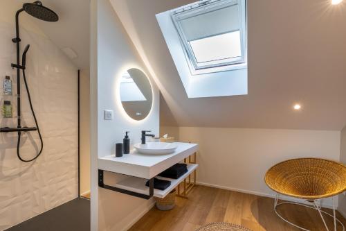 ein Badezimmer mit einem Waschbecken und einem Dachfenster in der Unterkunft La Burie in Saint-Savinien