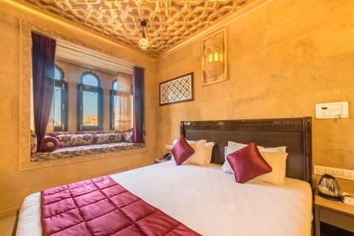 a bedroom with a large bed with red and white pillows at Hotel Sky Plaza - Best ever view of Jaisalmer Fort in Jaisalmer