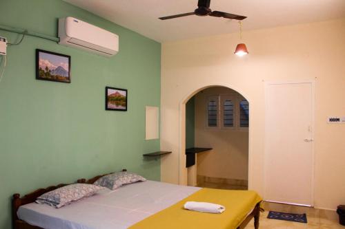 a bedroom with a bed and a ceiling fan at Dwaraka Guest House in Tiruvannāmalai