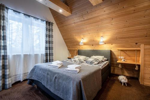 a bedroom with a bed in a wooden room at Willa Mountain Centrum in Zakopane