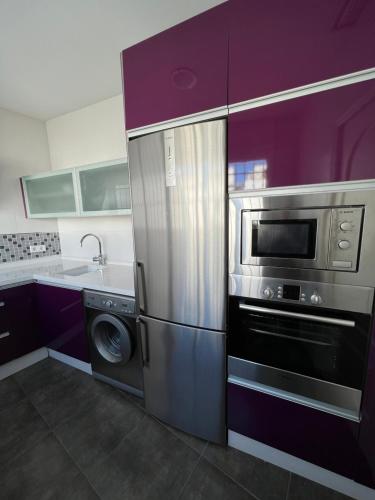 una cocina con frigorífico de acero inoxidable y lavavajillas en BALCÓN DE CLAUDIO MARCELO, en Córdoba