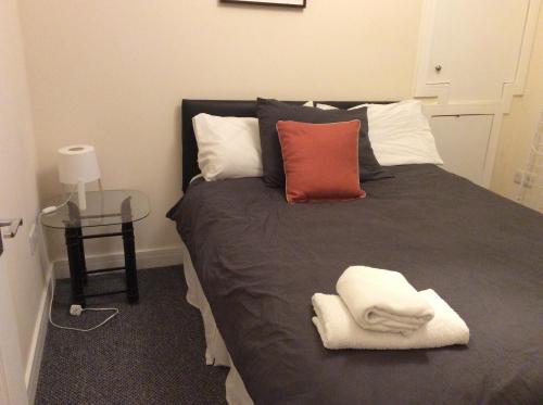 a bedroom with a bed with two pillows and a table at 103 Nelson Street Ground Right Largs in Largs