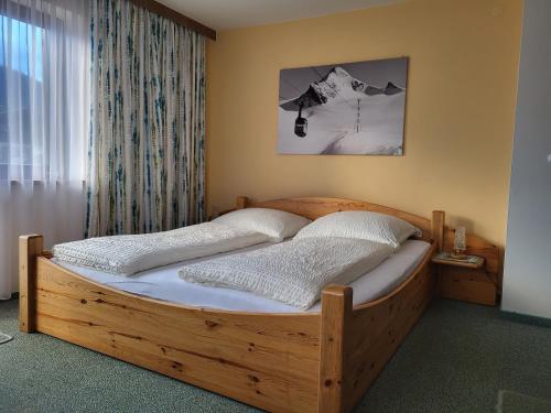 ピーゼンドルフにあるLandhaus Flatscherの窓付きのベッドルームの木製ベッド1台