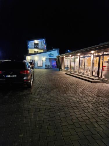 une voiture garée devant un bâtiment la nuit dans l'établissement Pensiunea Magia Voroneţului, à Voroneț