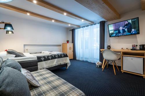 a hotel room with two beds and a flat screen tv at Willa Mountain Centrum in Zakopane