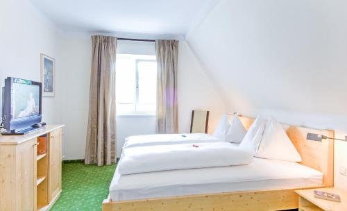 ペルトシャッハ・アム・ヴェルターゼーにあるFerienhaus Kleine Gartenvillaのベッド2台とテレビが備わるホテルルームです。