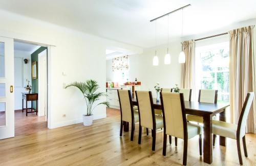 a dining room and living room with a table and chairs at Ferienhaus Kleine Gartenvilla in Pörtschach am Wörthersee