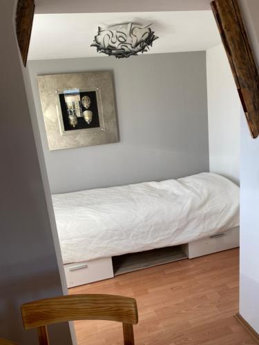 Bett in einem Zimmer mit Stuhl in der Unterkunft Ferienwohnung sentio-comfortable Saalfeld in Saalfeld