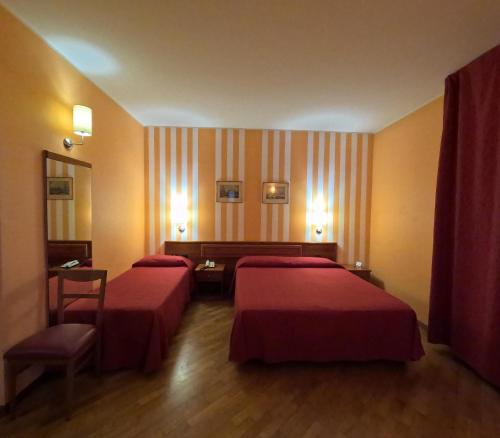 una habitación de hotel con 2 camas y un piano en Hotel Air Bag, en Lodi