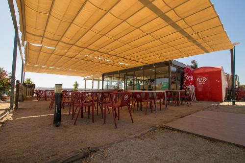 a group of tables and chairs under a yellow roof at Iate Glória Sem-fim Monsaraz in Monsaraz