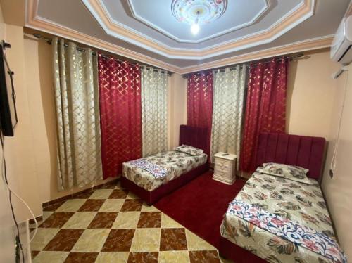 um quarto com duas camas e um piso de xadrez em coop auberge trt em Taourirt