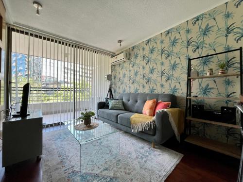 - un salon avec un canapé et une table en verre dans l'établissement Apartamentos City Centro Los Leones, à Santiago