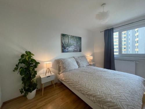 a bedroom with a bed with a plant and two lamps at 55 m2 Stylish Apartment with Balcony and Netflix in Vienna