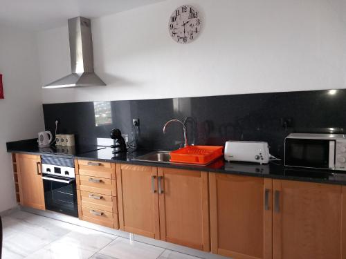 a kitchen with a sink and a microwave at Casa dos Avós Domingos & Matilde in Estreito da Calheta