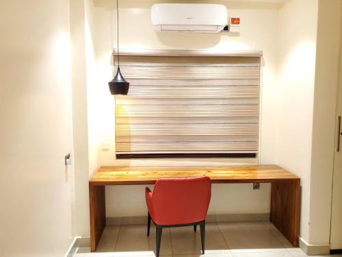 a desk in a room with a red chair at Millennium Terrace Hotel in Kampala