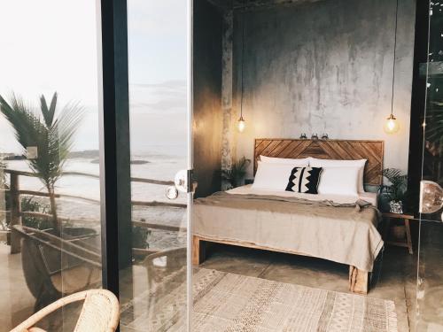 a bedroom with a bed with a view of the ocean at Morena Boutique Hotel Weligama in Midigama