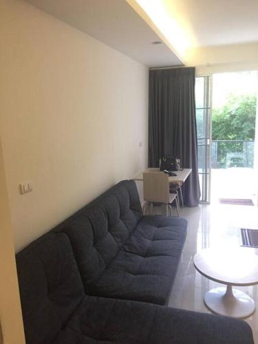 a living room with a blue couch and a table at Chaweng Beach Apartment 1 Schlafzi-1Wohnzi-Pool-Fitnes in Ban Ko Khwan