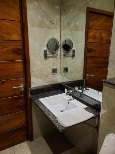 uma casa de banho com um lavatório e um espelho em Millennium Terrace Hotel em Kampala