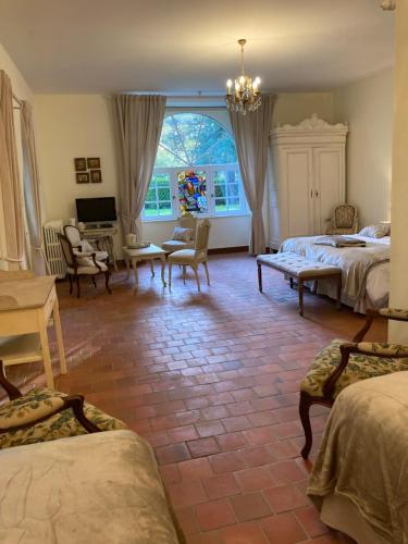 a bedroom with two beds and a television in it at Manoir de Saint-Fiacre in Malansac
