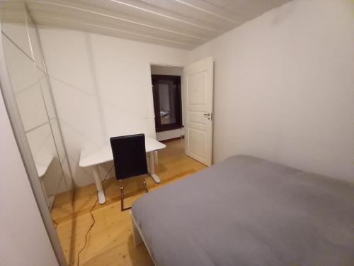 1 dormitorio con cama, escritorio y ventana en Private Room with No Windows in Shared House-5, en Umeå