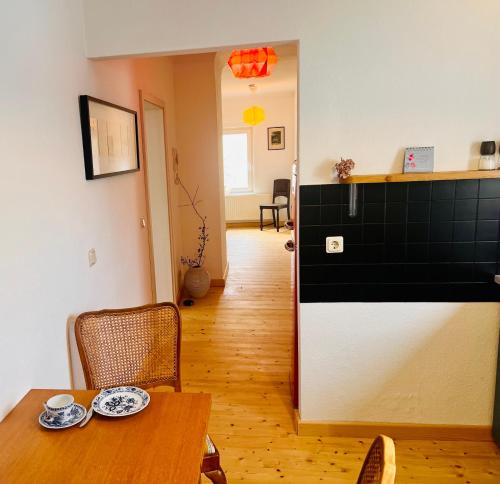 a dining room with a table and chairs and a hallway at Kuschelige helle Ferienwohnung in Gotha