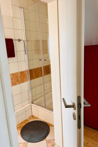 a shower in a bathroom with a rug on the floor at Kuschelige helle Ferienwohnung in Gotha