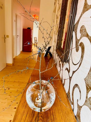 a glass bowl on a wooden table with branches in it at Kuschelige helle Ferienwohnung in Gotha