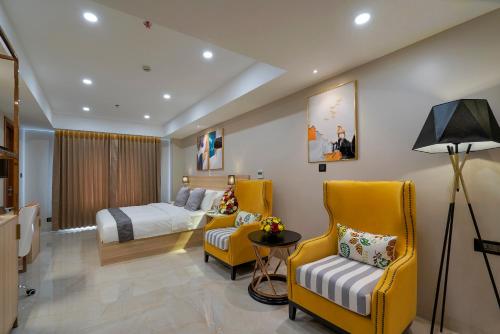 Habitación de hotel con 1 cama y 2 sillas amarillas en THE PORT BY JDANIELS, en Trivandrum
