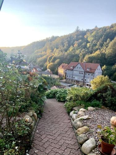 a stone path in a garden with houses and trees at Ferienwohnung am Hang mit malerischer Aussicht in Osterode