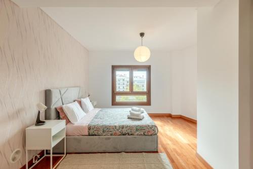 - une chambre blanche avec un lit et une fenêtre dans l'établissement Modern 2 bedroom apt 20 min from city center, à Amadora