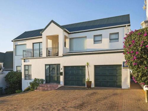 Casa blanca grande con puertas de garaje verdes en Eagles View Langebaan with Lagoon View, en Langebaan