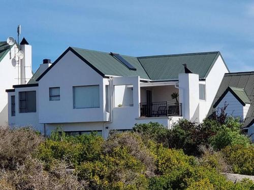 una casa blanca en la cima de una colina en Eagles View Langebaan with Lagoon View, en Langebaan