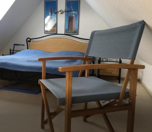 1 dormitorio con silla y 1 cama en Ferienwohnung Boddenblick en Zudar