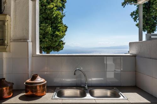 - un évier de cuisine avec vue sur l'océan dans l'établissement Villa Pasifika, à Loutrákion