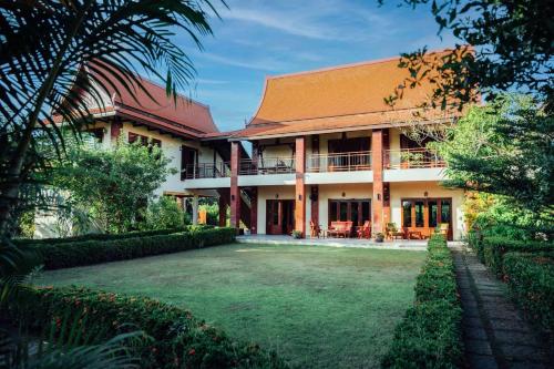 a house with a lawn in front of it at Nakara Villas & Glamping Udon Thani in Udon Thani