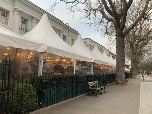 ein Restaurant mit weißen Zelten vor einem Gebäude in der Unterkunft Best Location! Town & Racecourse! in Cheltenham