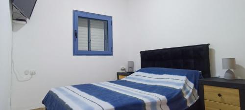 1 dormitorio con cama y ventana en Next to the marina, en Ashkelon