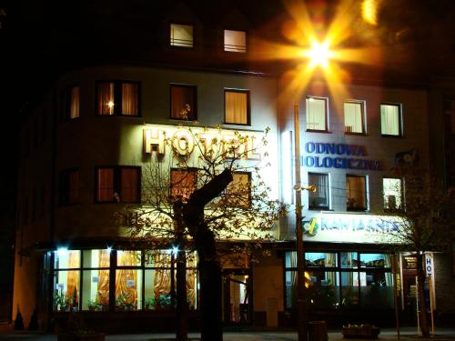 a building with a clock on the side of it at night at Hotel Anka in Słubice