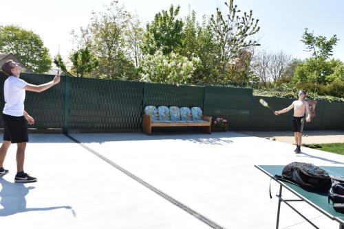 two men playing a game of tennis on a tennis court at Casa D&N in Passendale