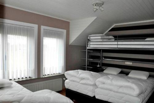 1 dormitorio con 2 camas y 2 ventanas en Casa D&N, en Passendale