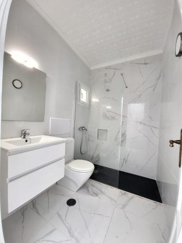een witte badkamer met een wastafel en een toilet bij Mar Bonanza in Orzola