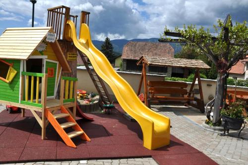 a playground with a slide and a play house at Gasthof Knappenwirt in Mariahof