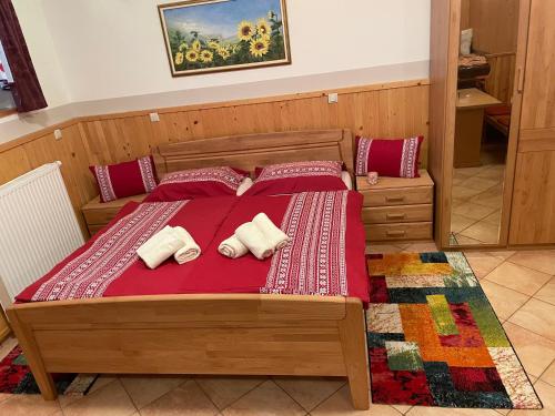 a bedroom with a bed with red sheets and pillows at Apartment & Studio Forest Paradise in Cerkno