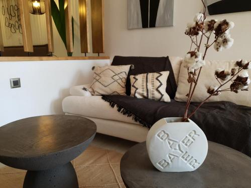a living room with a couch and a table with a vase at Costa Bianco Luxury Home in Agios Nikolaos