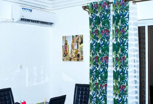 a room with a curtain with flowers on it at Appartement cosy Green bonapriso in Douala